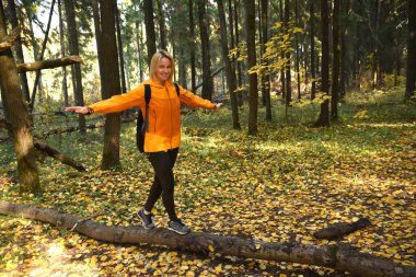 Ormanda sonbaharda yürüyüş için oynayan bir kız.