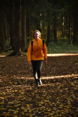 Ormanda sonbaharda yürüyen güzel bir kadın