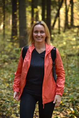 Ormanda sonbaharda yürüyen güzel bir kadın