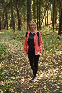 Ormanda sonbaharda yürüyen güzel bir kadın