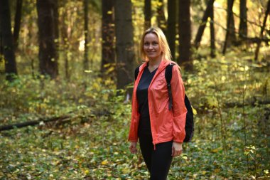 Ormanda sonbaharda yürüyen güzel bir kadın