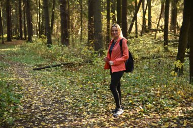 Ormanda sonbaharda yürüyen güzel bir kadın