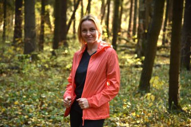 Ormanda sonbaharda yürüyen güzel bir kadın