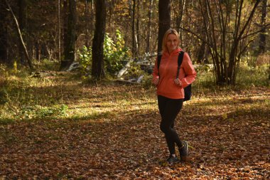 Ormanda sonbaharda yürüyen güzel bir kadın