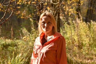 Ormanda sonbaharda yürüyen güzel bir kadın