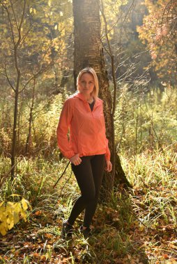 Ormanda sonbaharda yürüyen güzel bir kadın