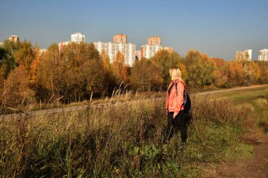 Sarışın, doğada şehrin dışında yürüyor.