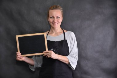 Gri arkaplanda ilan panosuna sahip güzel bir kadın.