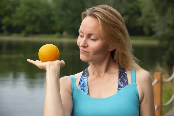 Piękna Dziewczyna Patrząc Pomarańczowy Dłoni Apetytem Naturę Lecie — Zdjęcie stockowe