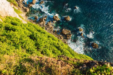 Bali 'de dalgalar ve taşlarla dolu bir okyanus. Hava görünümü