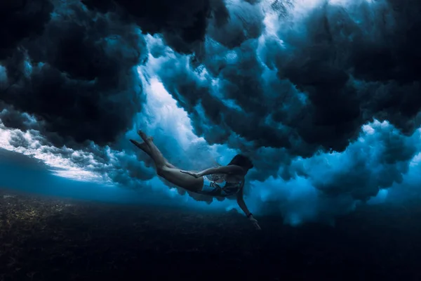 女性は海の波で水中で泳ぐ 波の下でアヒルダイビング — ストック写真