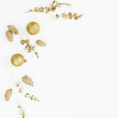 Beyaz arka planda altın süslemeli Noel kompozisyonu. Düz yerde, üst tarafta. Yeni yıl tatili