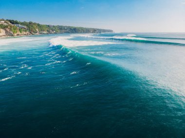 Okyanusta sörfçüler ve turkuaz varil dalgalarıyla Bali 'de hava manzarası.