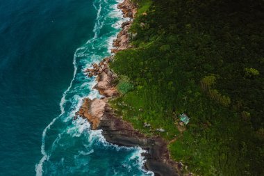 Scenic coastline with alone house, rocks and ocean with waves in Brasil. Aerial view