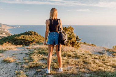 Attractive sporty woman in shorts posing outdoor on coastline.