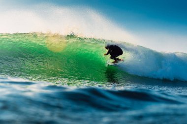 15 Şubat 2022. Brezilya, Florianopolis. Sabahları sörf yapan adam. Sörfçü varil dalgasında sörf tahtasında. 