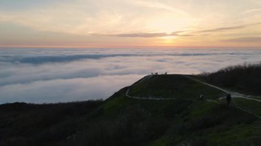 Gün batımlı hava manzarası ve dağlarda sürünen sis. Sisli hava