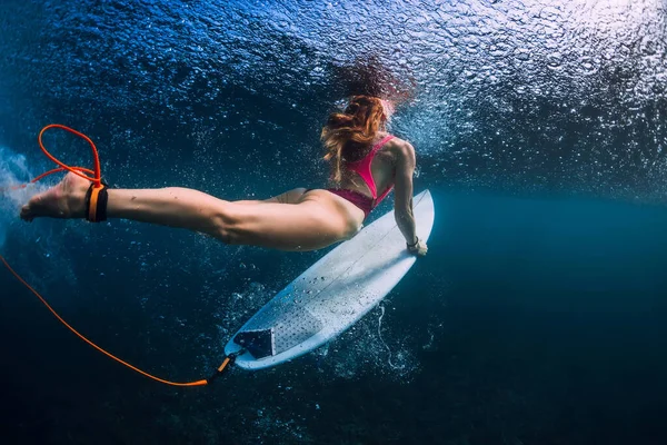 近くで見るアップビューのサーファー女性とともにサーフボードダイブ水中で青い海 — ストック写真