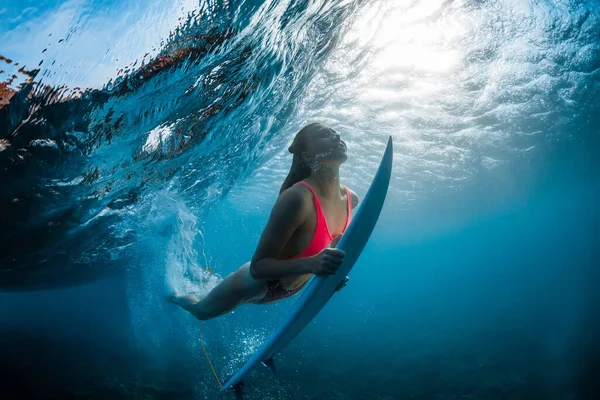 透明海でバレル波と日光の下で水中でサーフボードダイブとサーファーの女性 — ストック写真