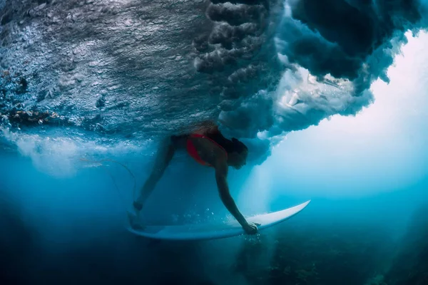 海の波の下でサーフボードダイビングとプロのサーファーの女性 — ストック写真