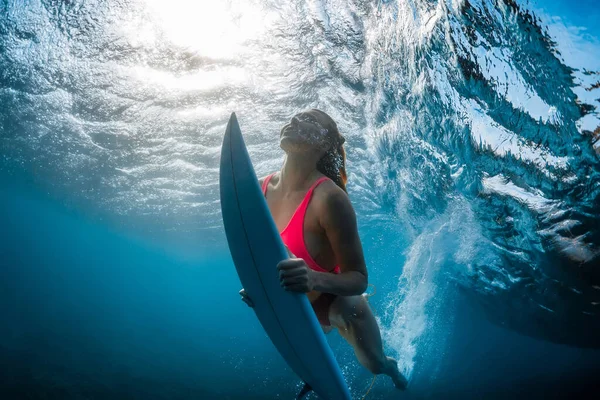 파도타기 속으로 다이빙하는 파도타기하는 소녀의 파도와 아래서 잠수하는 — 스톡 사진