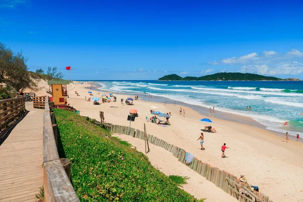 8 Ocak 2022. Florianopolis, Brezilya. İnsanlarla dolu bir tatil plajı ve Brezilya 'da dalgalı mavi bir okyanus. Florianopolis 'teki Morro das Pedras plajı