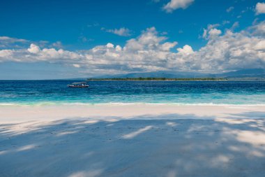 Cennet adasındaki kumsal ve mavi okyanus. Beyaz kum ve turkuaz deniz suyuyla tatil kumsalı.