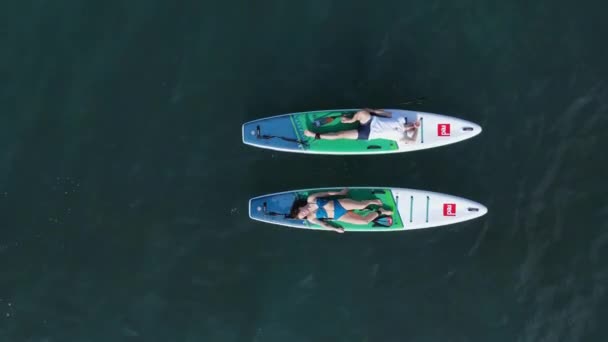 2022年4月19日 保加利亚 索佐波尔一对夫妇站在蓝色海的船桨板上 人们在海上的红色船桨上放松 空中景观 — 图库视频影像