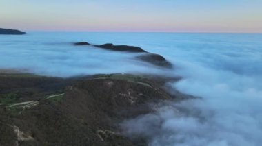 Sürünen sis ve dağlarla hava manzarası. Sisli hava