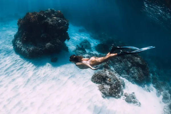穿着比基尼的女自由潜水者 带着热带珊瑚在沙滩底部潜水 迷人的身材苗条的女孩 水下有鳍 — 图库照片
