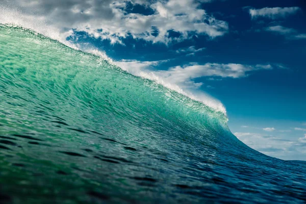 Turquoise wave with sun light breaking in ocean