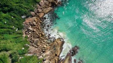 Taşlı kıyı şeridi ve dalgalı şeffaf okyanus. Hava görünümü