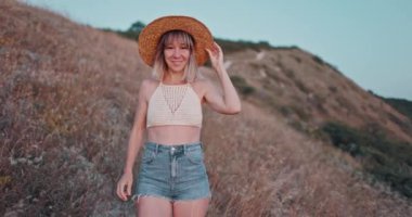 Şapkalı kadın portresi kameraya mutlu bir şekilde bakın günbatımı tonlarıyla başarılı bir yaşam tarzının keyfini çıkarın.