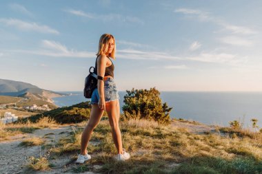 Deniz kıyısında açık havada poz veren şortlu çekici bir kadın..