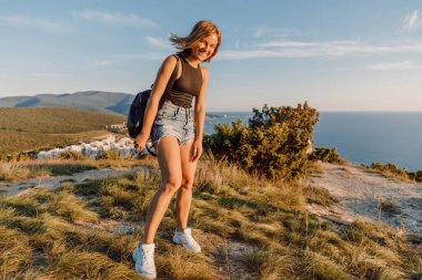 Mutlu duyguları olan çekici bir kadın okyanus kıyısında poz veriyor..