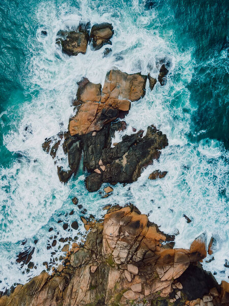 Rocky ocean coastline with waves and foam in Brazil. Aerial view