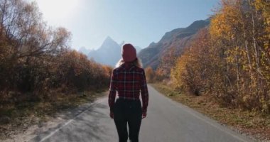Genç bir kadın Kanada 'da sonbahar dağlarında yürüyor.