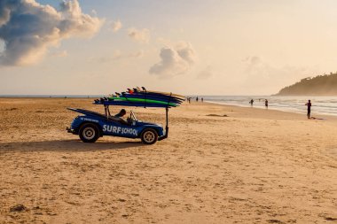 May 1, 2022. Florianopolis, Brazil. Holiday beach with car of surf school and walking people on ocean with waves in Brazil. Morro das Pedras beach in Florianopolis