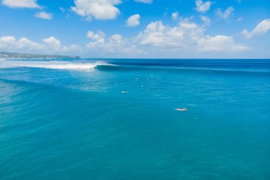 Aerial view of big blue waves and surfers in Bali. Balangan beach