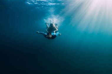 August 07, 2021. Varna, Bulgaria. Men free diver with fins in blue sea and sun rays. Freediving underwater in transparent sea
