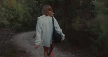 Woman walking along on the path in outdoor with sunset light. Weekend in the mountains