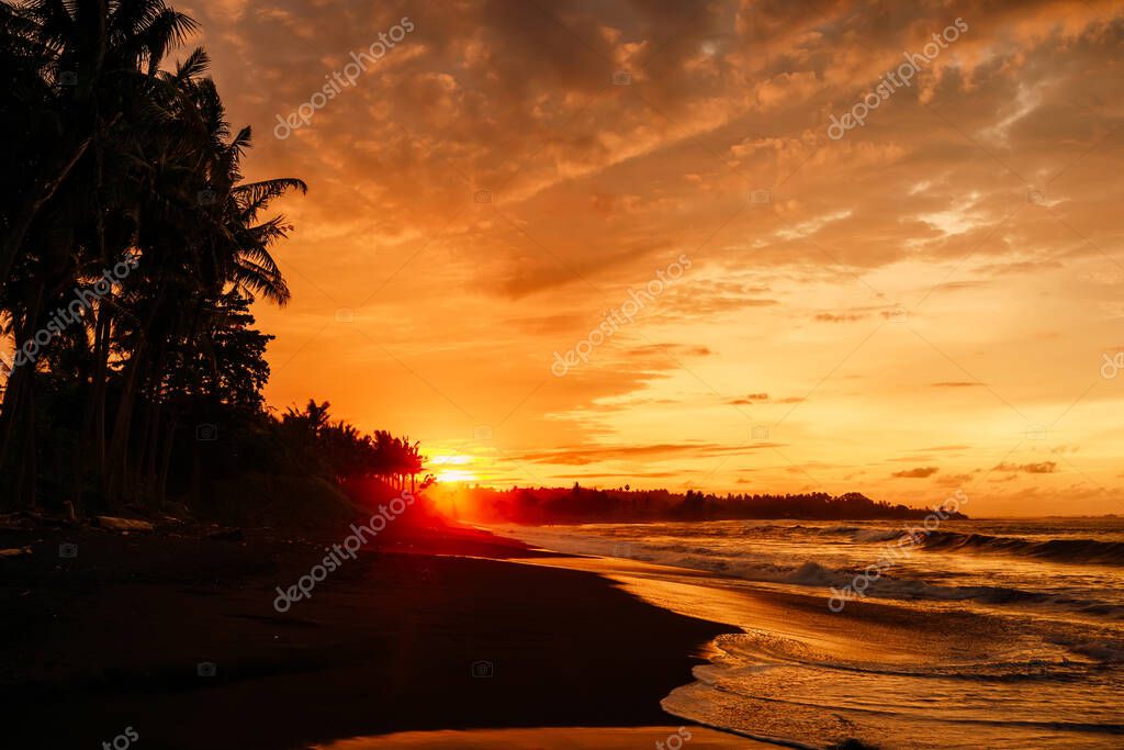 Puesta o salida del sol con olas oceánicas y palmeras de coco en los