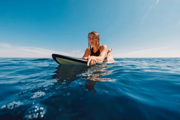 ポートレートの魅力的なブロンドサーフィン女の子オンサーフボードで海でサーフィン中 — ストック写真