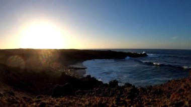 Lanzarote, Kanarya Adaları 'ndaki lav kayalıkları ve okyanus dalgalarıyla plajda aşırı kayma.
