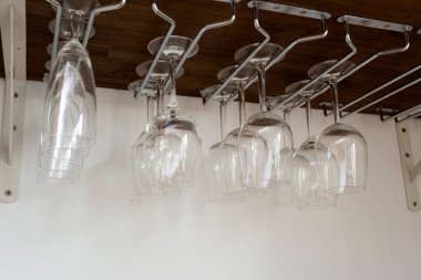 Tutucuda asılı duran şarap kadehleri. Dolabın içinde organize edilmiş. ev içi depo kapanıyor.