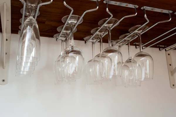 Tutucuda asılı duran şarap kadehleri. Dolabın içinde organize edilmiş. ev içi depo kapanıyor.