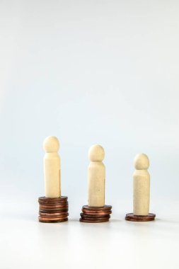 Farklı yükseklikteki madeni paraların üzerinde duran minyatür insanlar. Kişilik ve zenginlik kavramları. İş ve finansal konsept beyaz arka planda izole edilmiş, kopyalama alanı var. Biri fakir, diğeri zengin biri ise metin için.