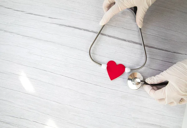 Jantung Merah Dan Sarung Tangan Medis Putih Pelindung Memegang Stetoskop — Stok Foto