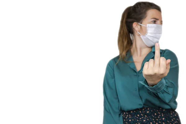 Female raise the middle finger middle finger hand sign wearing a white protective facial mask for pandemic, Covid-19, away with coronavirus concept isolated on white background copy space