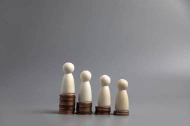 Farklı yükseklikteki madeni paraların üzerinde duran minyatür insanlar. Kişilik ve zenginlik kavramları. Yatırım ve takım çalışması büyüme kopyalama alanı